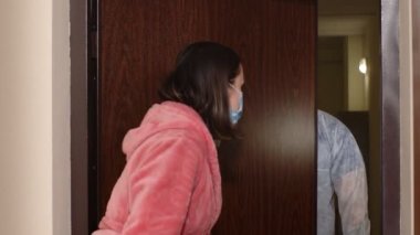 Yazılı metni olan doktor, Coronavirus 'a karşı aşı önererek evdeki kadını ziyaret ediyor.