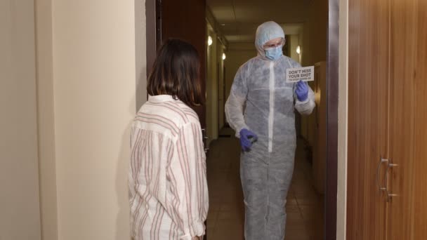 Medical worker with text on paper visiting woman at home offering vaccination against coronavirus — Stock Video