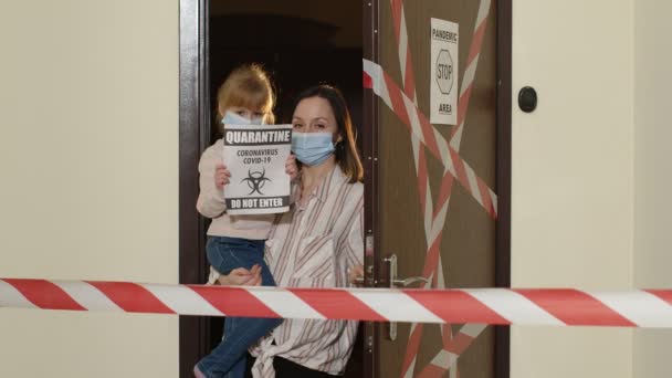Madre malata con figlioletta in maschera medica che apre la porta di casa, isolamento di quarantena coronavirus — Video Stock