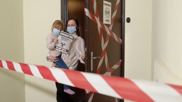 Madre enferma con hija pequeña en máscaras médicas que abren la puerta de casa, bloqueo de cuarentena por coronavirus — Vídeo de stock