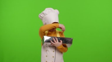 Çocuk kız aşçı önlüklü aşçı ve şapkalı hamura kuru üzüm, ekmek, pasta...