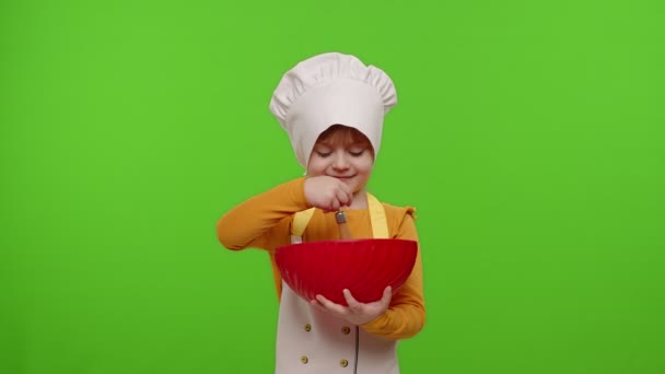 Enfant fille habillé comme cuisinier chef boulanger mélanger la pâte dans un bol, préparer le gâteau sur fond chroma clé — Video