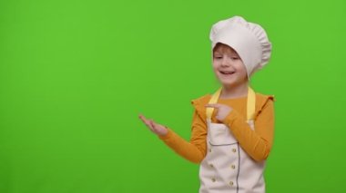 Aşçı kız önlüklü aşçı kız krom anahtar arka planında boş bir alanı işaret ediyor.