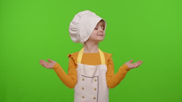 Bambino ragazza bambino vestito cuoco cuoco in grembiule che punta a destra ea sinistra sullo spazio vuoto, croma chiave — Video Stock