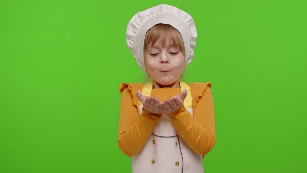 Child girl kid dressed as professional cook chef blowing flour from hands into camera on chroma key — Stock Video