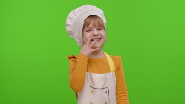 Ребенок девочка одета повар пекарь в фартук и шляпа смеется вслух, услышав смешную шутку — стоковое видео