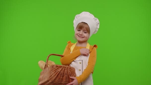 Köchin-Kind zeigt Korb mit Baguette und Brot, lächelt und schnuppert an Chroma-Schlüssel — Stockvideo