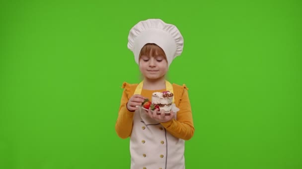 小女孩打扮成职业厨师烘焙师，用彩色钥匙吃美味的草莓蛋糕 — 图库视频影像