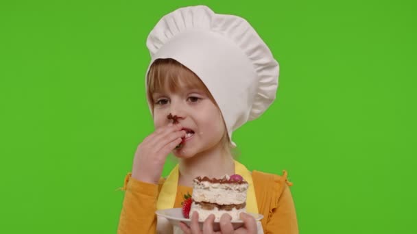 Child girl kid dressed as professional cook chef showing eating tasty handmade strawberry cake — Stock Video