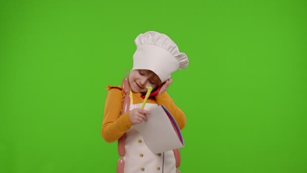 Menina garoto cozinheiro chef recebendo ordem on-line, escrevendo com caneta no notebook falando no telefone celular — Vídeo de Stock