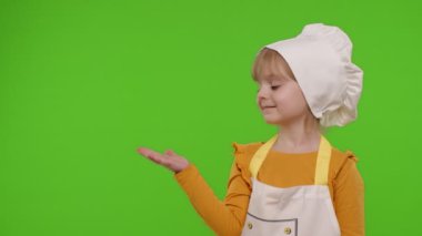 Aşçı gibi giyinmiş çocuk boş yeri işaret ediyor. Reklam logonuz için.
