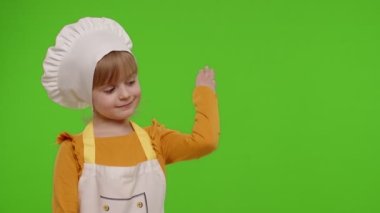 Aşçı gibi giyinmiş çocuk, reklam logonuz için boş yeri işaret ediyor.