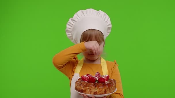 Niño niña vestido como cocinero chef espolvorear pastel de fresa con azúcar en polvo, croma clave fondo — Vídeos de Stock