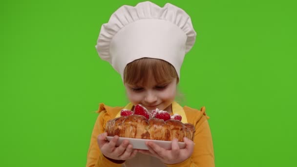 Niño niña vestido como cocinero chef espolvorear pastel de fresa con azúcar en polvo, croma clave fondo — Vídeo de stock