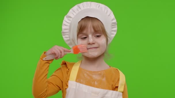 面白い子供の女の子の子供は、エプロンと帽子のダンスでコックシェフのパン屋を身に着けていました,周りを欺く,顔を作る — ストック動画