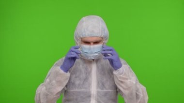 Kişisel PPE koruyucu takım elbiseli tıp çalışanı doktor. Krom anahtarlı gözlük takıyor.
