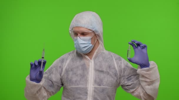 Γιατρός με στολή ΜΑΠ με αμπούλα εμβολίου, σύριγγα στα χέρια που προσφέρει εμβολιασμό κατά του κορωναϊού — Αρχείο Βίντεο