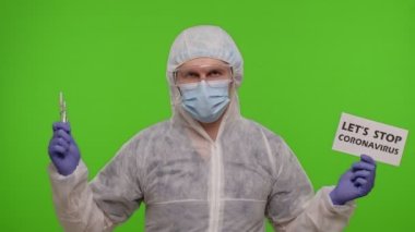 Kağıt üzerinde şırınga, ampul ve metin sloganı olan PPE kostümlü doktor Coronavirus 'u durduralım, kroma anahtarı.