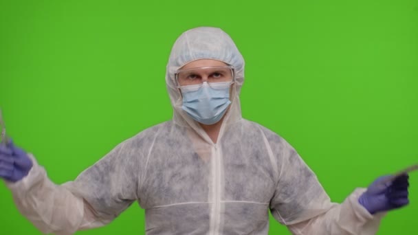 Doctor in PPE pak met spuit, ampul en tekst slogan op papier Laten we stoppen met Coronavirus, chroma key — Stockvideo