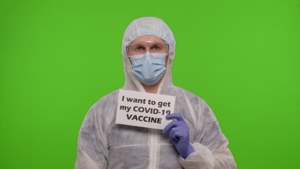 Doctor in suit with syringe, ampoule and text slogan on paper - I Wand To Get My Covid-19 Vaccine — Stok Video
