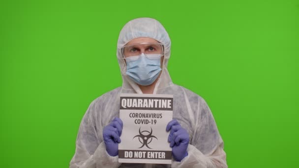 Medico in tuta mostrando slogan testo di avvertimento su carta - Quarantena Covid-19 Coronavirus Non entrare — Video Stock