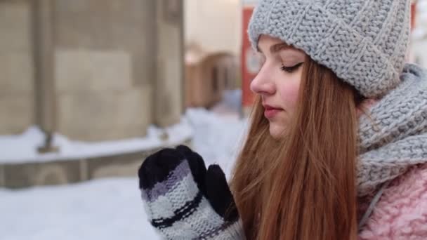 Primer plano de la joven turista calentando sus frías manos al aire libre en el día de invierno en la calle de la ciudad — Vídeos de Stock