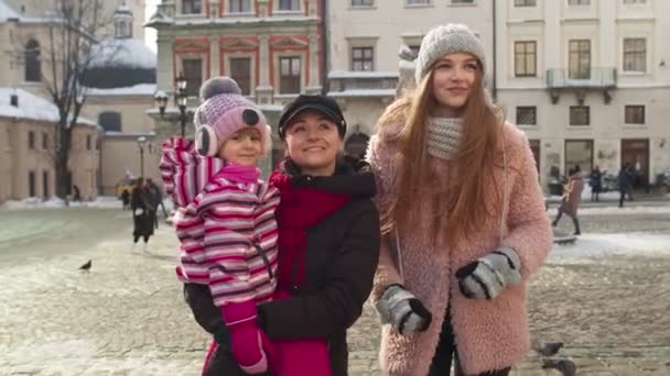 Turister systrar par med yngre syster barn flicka promenader i staden, talar med leenden utomhus — Stockvideo