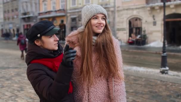 Duas mulheres sorridentes turistas andando juntos na rua da cidade, casal de família conversando, abraçando — Vídeo de Stock