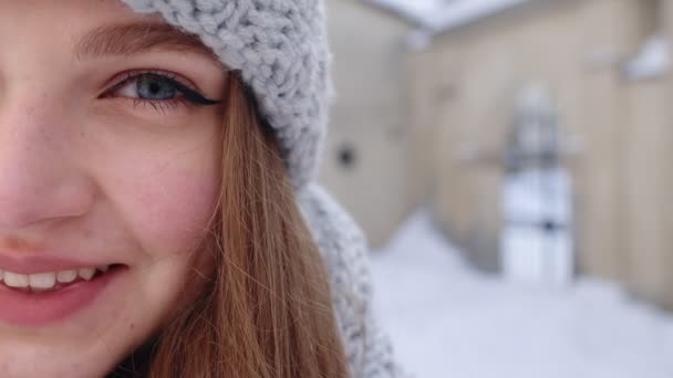 Primer plano de alegre cara de mujer joven positiva sonriendo a la cámara mientras está de pie al aire libre en invierno — Vídeos de Stock