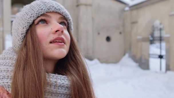 Primer plano de alegre cara de mujer joven positiva sonriendo a la cámara mientras está de pie al aire libre en invierno — Vídeos de Stock