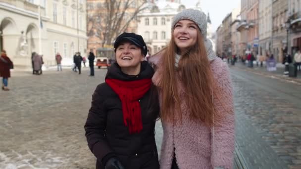Twee lachende vrouwen zusters toeristen lopen samen op straat, jong stel praten, omarmen — Stockvideo