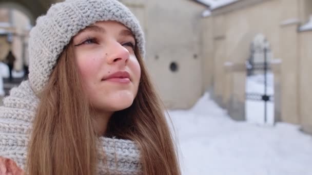 Retrato de chica bastante feliz caucásica con sonrisa en la cara posando en el fondo de la ciudad de invierno — Vídeos de Stock