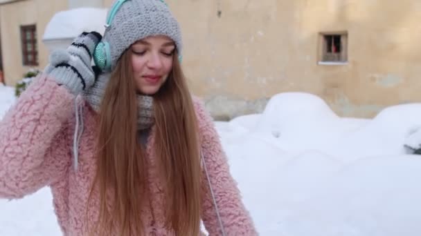 Chica turística durante sus vacaciones escuchando música a través de auriculares y bailando en el centro de la ciudad vieja — Vídeos de Stock