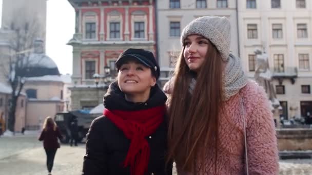 Två leende kvinnor systrar turister gå tillsammans på stadens gata, par prata, omfamna — Stockvideo