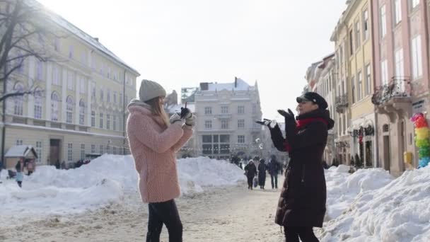 Δύο νεαρές χαμογελαστές γυναίκες τουρίστες bloggers τραβώντας φωτογραφίες πορτρέτο στο κινητό τηλέφωνο στην οδό της πόλης — Αρχείο Βίντεο