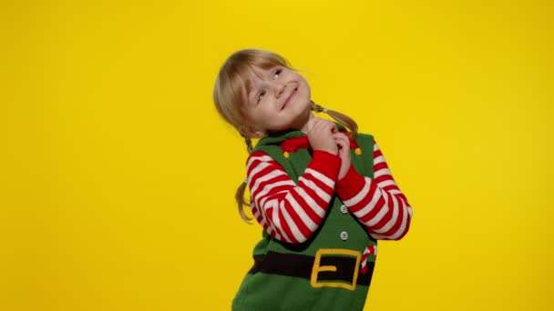 Концепція різдвяного бажання. Дитяча дівчинка-підліток в костюмі різдвяного ельфа Санта помічника робить бажання, молиться — стокове відео