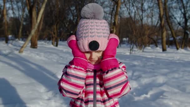 Glada barn flicka visar wow glädje effekt gest, unge lyfta händerna i överraskning i vinter park — Stockvideo
