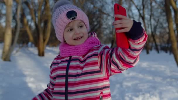 Niños niños bloguero saludando, haciendo videollamadas, transmisión en línea en las redes sociales en el parque de invierno — Vídeos de Stock