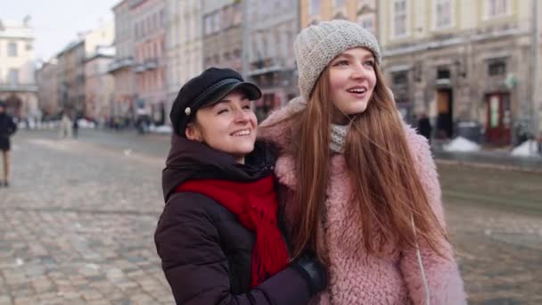 Due donne sorridenti turisti che camminano insieme sulla strada della città, coppia di famiglia che parla, abbracciando — Video Stock