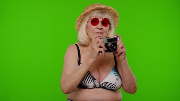 Старша жінка туристичний фотограф фотографує ретро-камеру і посміхається на ключовому фоні хромосоми — стокове відео