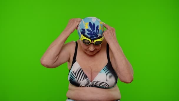 Senior woman tourist wearing swimming glasses, looking at camera, dancing on chroma key background — Stock Video