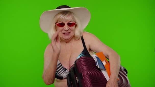 Starší babička turista mává rukou Ahoj vítejte, žena se zavazadly, pas, vstupenky — Stock video
