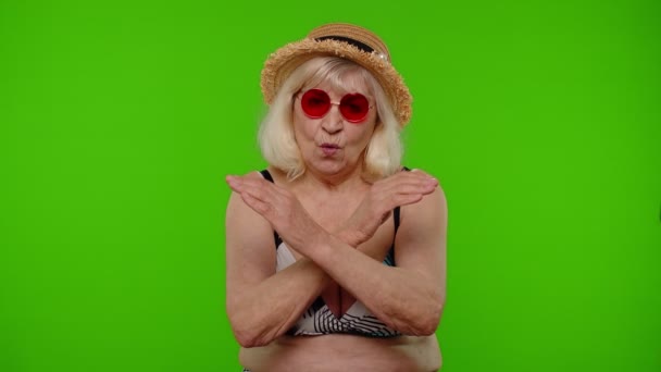 Donna matura viaggiatore in occhiali da sole rossi che mostrano segno di stop, antipatia gesto, cattiva idea, scelta sbagliata — Video Stock