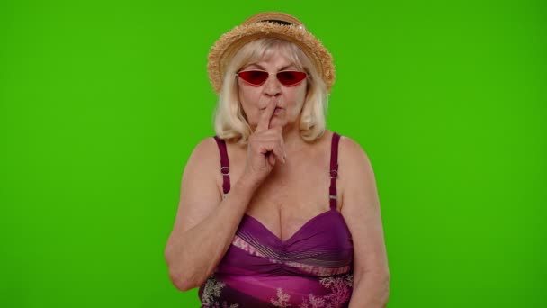 Mulher idosa turista segurando o dedo perto dos lábios para sinal de silêncio, silêncio, segredo, silêncio na chave chroma — Vídeo de Stock