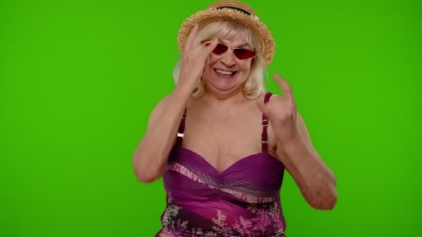 Donna anziana turista in costume da bagno ballare, festeggiare, mostrare lingua, rock and roll gesti mano — Video Stock