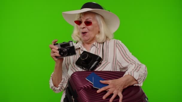 Зріла жінка-фотограф мандрівник в сонцезахисних окулярах робить фотографії на ретро-камеру, ключ хроми — стокове відео