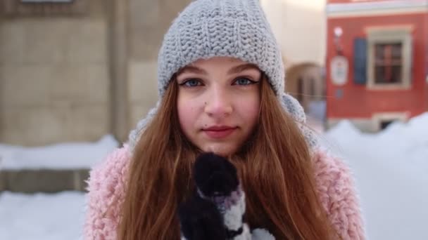 在城市街道寒冷的天气里，微笑的旅行女孩戴着手套揉着手，想保暖 — 图库视频影像