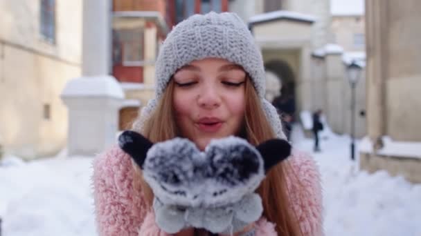 Giovane viaggiatore donna turista mostrando la neve nelle mani palme alla macchina fotografica e soffiando sulla strada della città — Video Stock