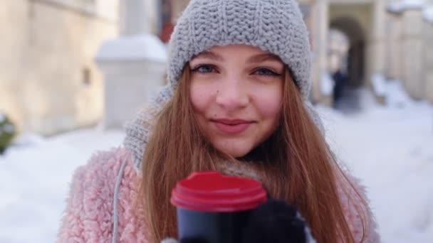 Стильная женщина путешественник с горячим напитком в чашке глядя вокруг через улицу города во время отпуска — стоковое видео