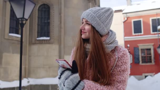 Mujer viajera joven caminando por la ciudad vieja sosteniendo el teléfono móvil, charlando con amigos y familiares — Vídeos de Stock